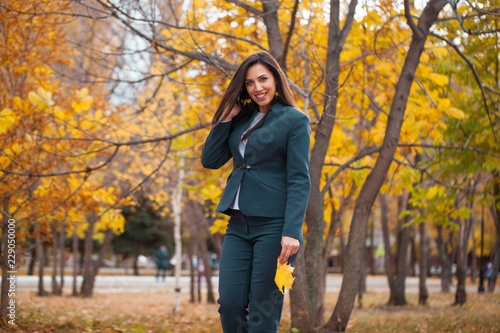Happy arab businesswoman in blue suit walking in autumn park © Andrey_Arkusha
