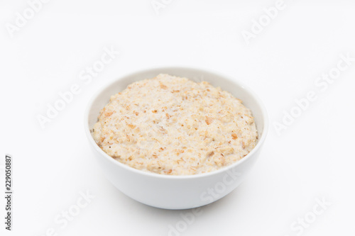 Oatmeal in white plate on white background. Isolated on white