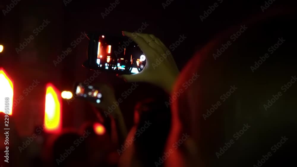 Fans are filming a concert on a smartphone. Live broadcast of the concert in social networks. People make photos and videos at the festival. World tour of popular musicians Fans are filming a concert on a smartphone. Live broadcast of the concert in social networks. People make photos and videos at the festival. World tour of popular musicians