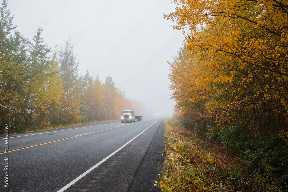 truck on highway in thick autumn fog