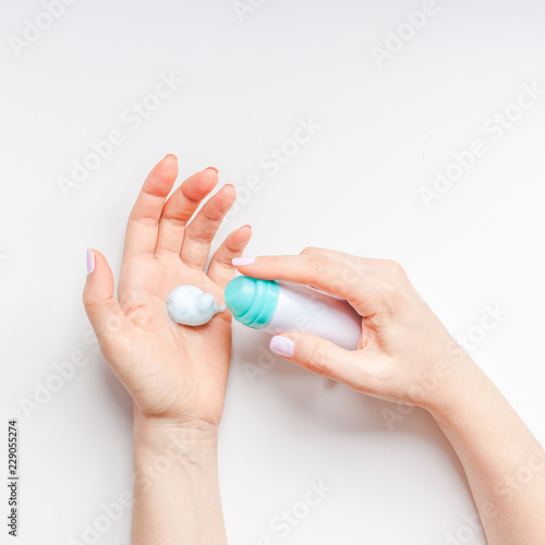 Woman moisturizing her hands with foam lotion