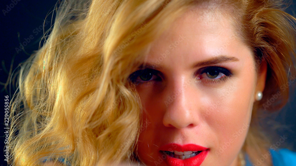 Fototapeta premium Portrait cropped shot woman with beautiful eyes and long wavy hair. Fun and inviting world of fashion. Girl with long hair froze in fright on dark background. Girl seduces guy.