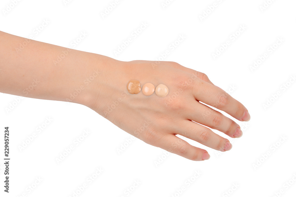 Fair, medium, dark swatches  of foundation on the hand isolated on white.