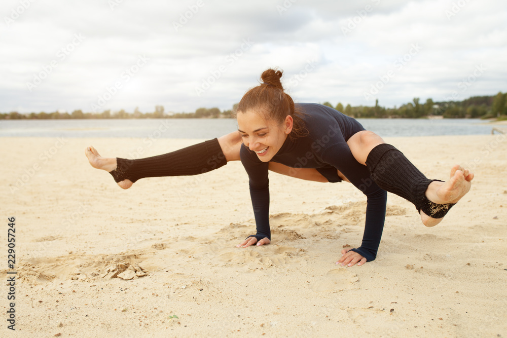 Beautiful middle-aged girl doing yoga exercises on the shore of a beautiful lake on a sunny autumn day Beautiful middle-aged girl doing yoga exercises on the shore of a beautiful lake on a sunny autumn day