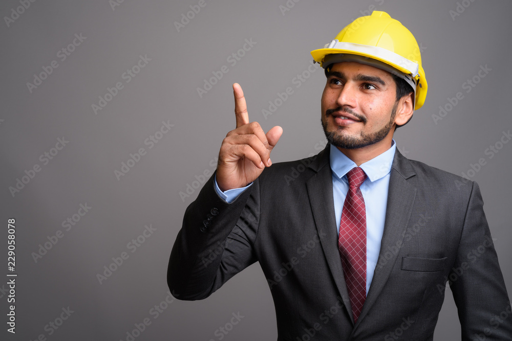 Young handsome bearded Persian businessman wearing hardhat again Young handsome bearded Persian businessman wearing hardhat again