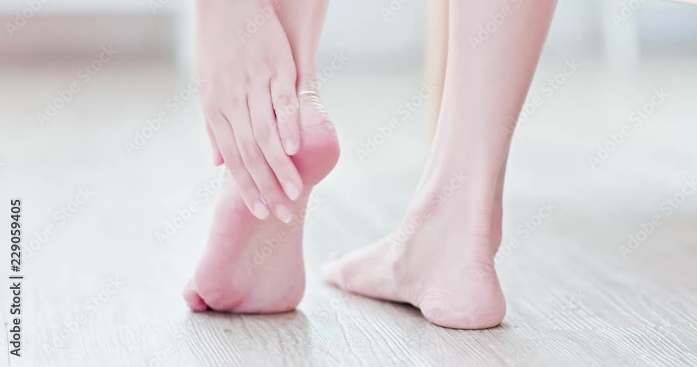 Woman applying cream onto foot Woman applying cream onto foot