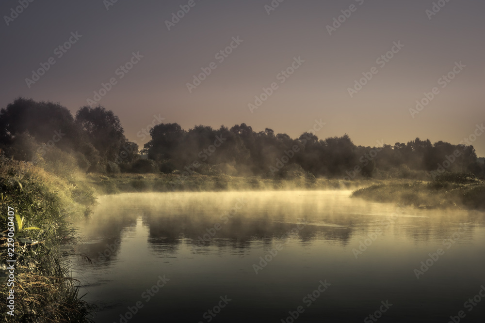 countryside morning sunrise river mist scenery landscape  wit htranquil foggy water mirror and dark dramatic moody sky 