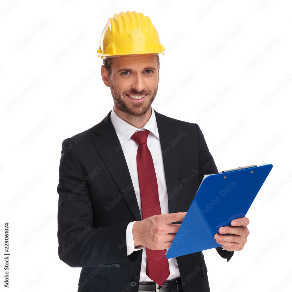 smiling businessman wearing a protection helmet holds blue files smiling businessman wearing a protection helmet holds blue files