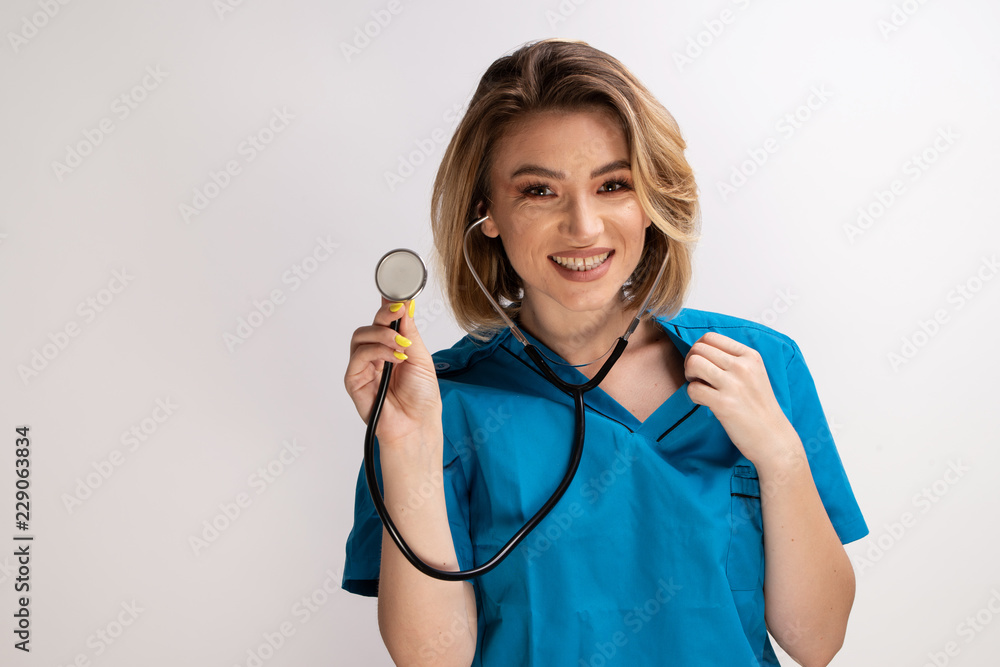 Female doctor displaying a stethoscope to the camera. Isolated shot on white background with copy space