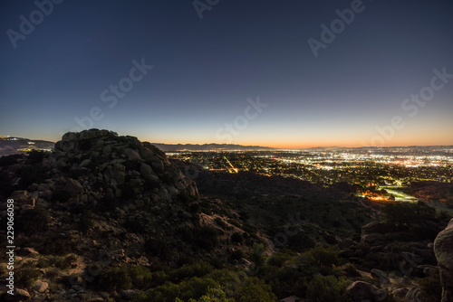 Los Angeles California predawn rocky hilltop view of the San Fernando Valley. Burbank, North Hollywood, Griffith Park and the San Gabriel Mountains are in background. 