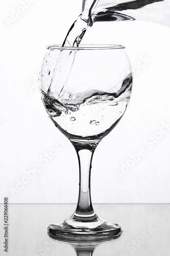 A splash of water in a wineglass on a white background.