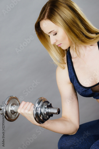 Fit woman lifting dumbbells weights