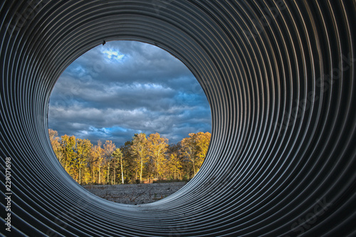 view of sunset woods through large culvert photo