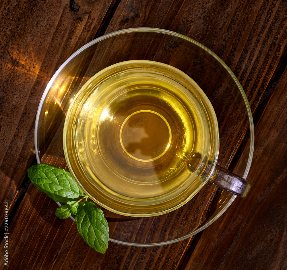 Green tea in cup with leaves on wooden table from top or top view Green tea in cup with leaves on wooden table from top or top view