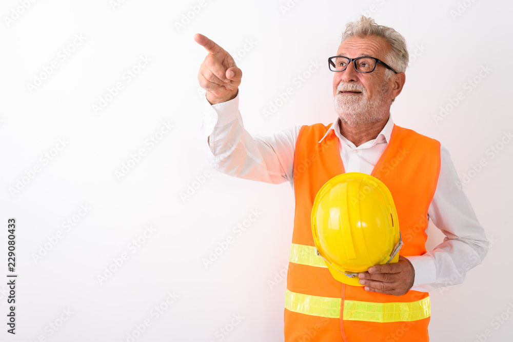 Studio shot of happy senior bearded man construction worker smil Studio shot of happy senior bearded man construction worker smil