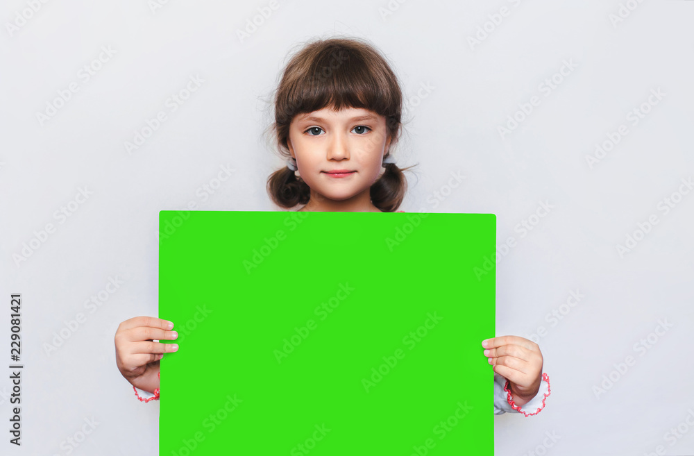 The little girl is holding a blank sheet of paper. Ukrainian patriots. Education. Advertising. Copy space, chroma key. The little girl is holding a blank sheet of paper. Ukrainian patriots. Education. Advertising. Copy space, chroma key.