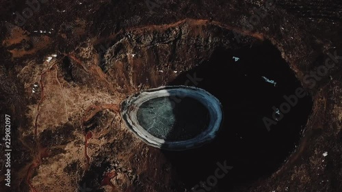 Aerial: Volcanic crater filed with frozen water. Kerid crater lake. Iceland