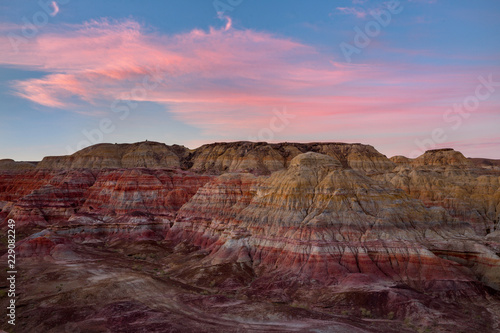 Rainbow Hills in China. Rainbow City  Wucai Cheng. Colorful layered landforms in a remote desert area of Fuyun County. Uygur Autonomous Region  Xinjiang Province. Sunrise - Pink  Purple and Blue Sky