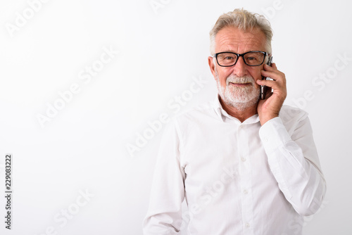 Studio shot of happy senior bearded man smiling while talking on © Ranta Images