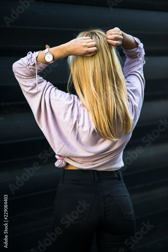 Photographing a girl during autumn near a high-tech glass building with a blurred background of the park