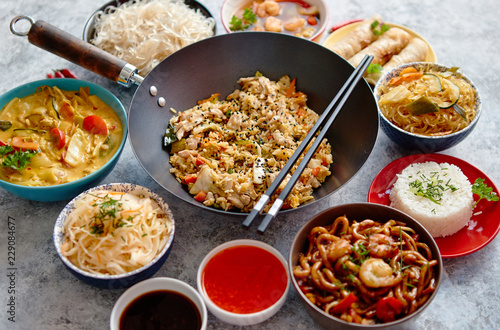 Chinese food set. Chinese noodles, fried rice with chicken, tom yum soup, spring rolls, deep fried fish and udon. Top view. Asian style food concept composition.