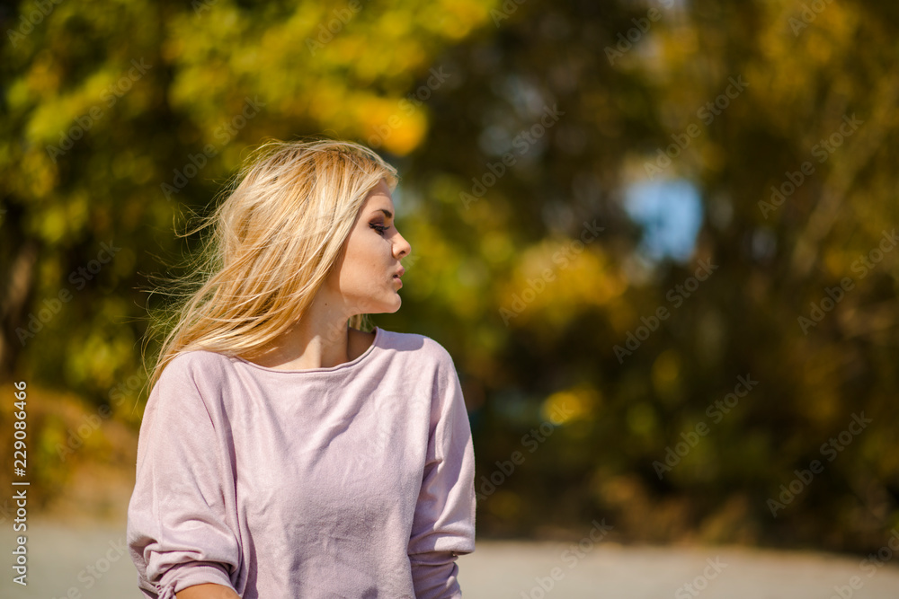 Photographing a girl during autumn on a beach near a river with a blurred background Photographing a girl during autumn on a beach near a river with a blurred background