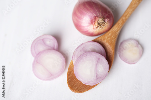 Sliced red shallot onion on wooden spoon, herb and spice, food ingredient
