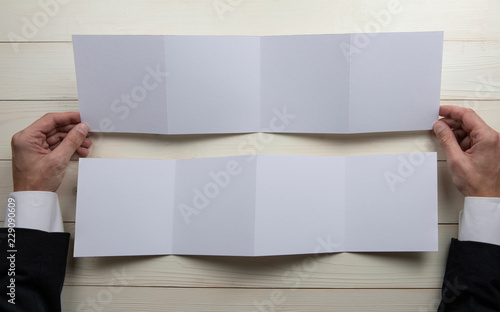Mens hands holding empty white booklet © fontgraf