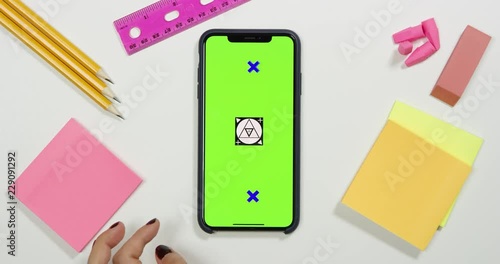 Using a green screen phone on a white work arts and crafts desk