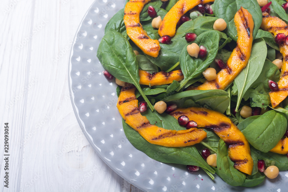 Autumn salad with pumpkin , spinach , pomegranate and chickpea