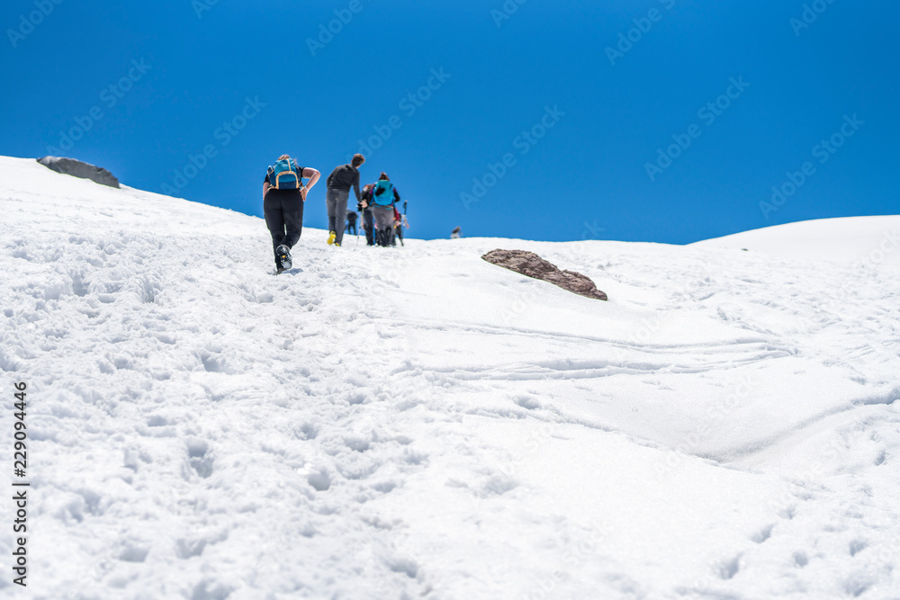 People doing trekking inside Andes valleys, crossing a snow valleys in central Chile at Cajon del Maipo, Santiago de Chile, amazing views over mountains and glaciers with awesome hiking exploration