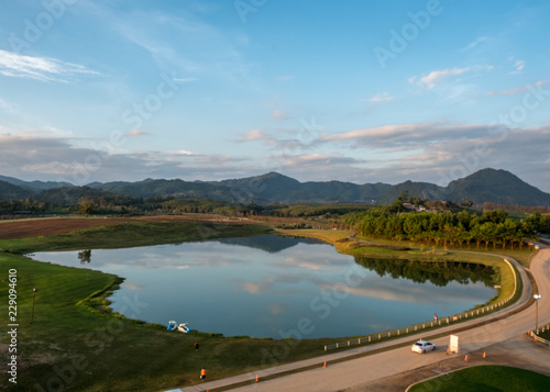 Beautiful landscape with high mountain , reflection in mountain lake, blue sky and mist cover the peak of hill. Singha Park, Chiang Rai, North of Thailand