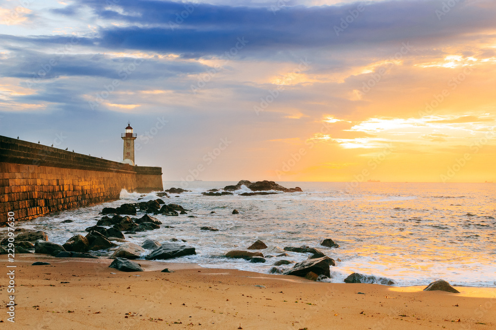 lighthouse on beach at sunset
