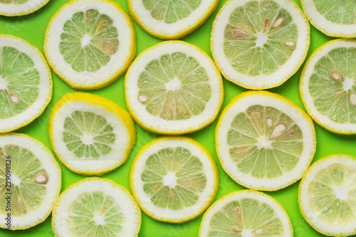 Pattern of juicy ripe slices lemon on green background. Fruit minimal concept. Flat lay.