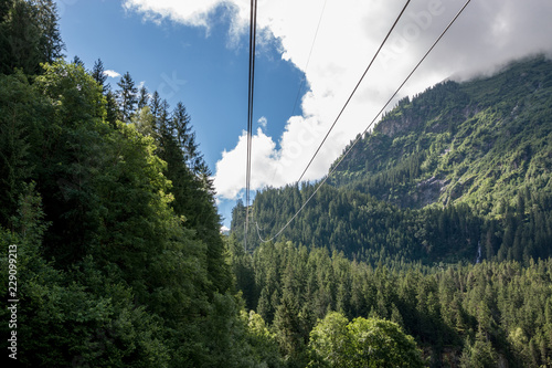 Closeup mountains scenes, cable car to Trift Bridge in national park Switzerland, Europe. Summer landscape, sunshine weather, cloudy sky and sunny day