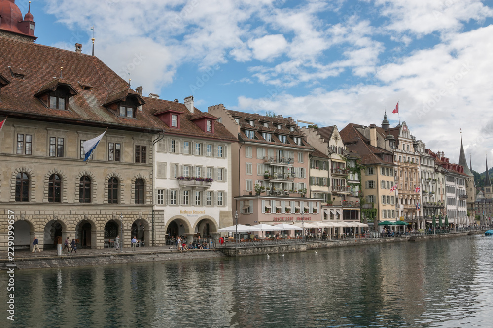 Lucerne, Switzerland - July 3, 2017: Panoramic view of city center of Lucerne and river Reuss. Summer landscape, sunshine weather, dramatic blue sky and sunny day