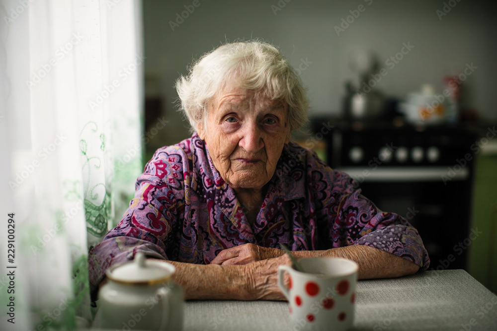 Portrait of an elderly woman sitting at the table.