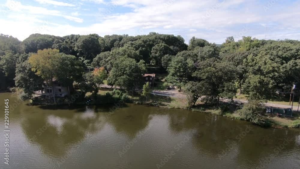 Suburban lake community in the Hudson Valley. Drone pans up high overhead. Suburban lake community in the Hudson Valley. Drone pans up high overhead.