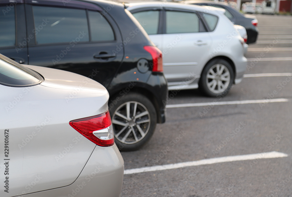 Closeup of rear side of white car park in parking area in the evening.