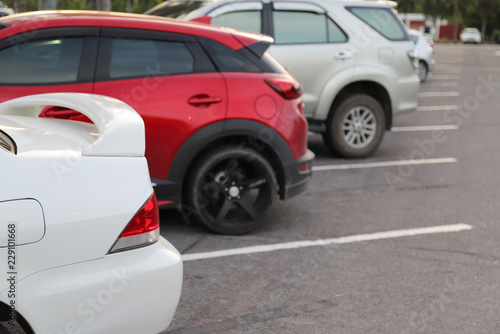 Closeup of rear side of white car park in parking area in the evening.