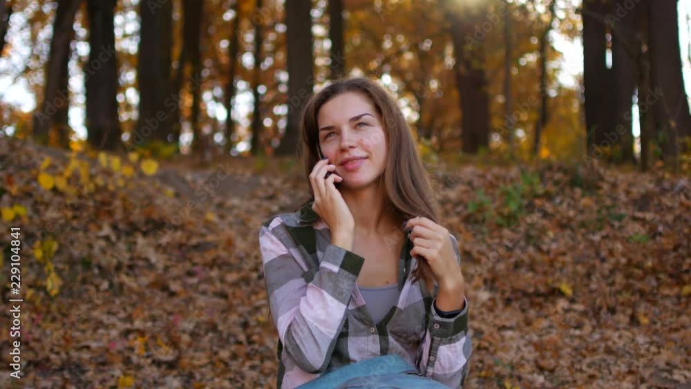 Girl in yellow forest. Woman talking on the phone in the autumn forest. Girl in yellow forest. Woman talking on the phone in the autumn forest.
