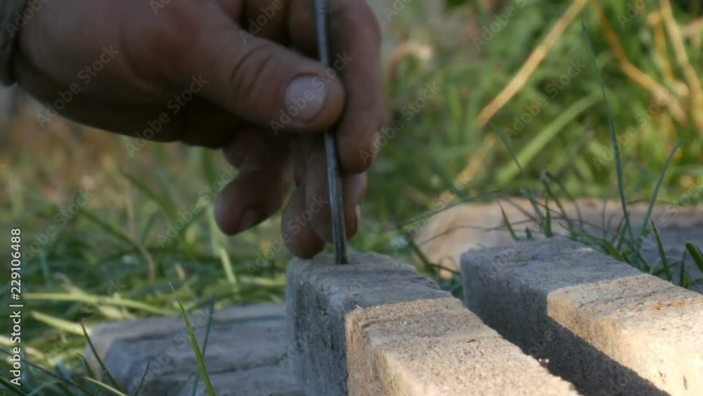 Man hammering used long nail into old boards Man hammering used long nail into old boards