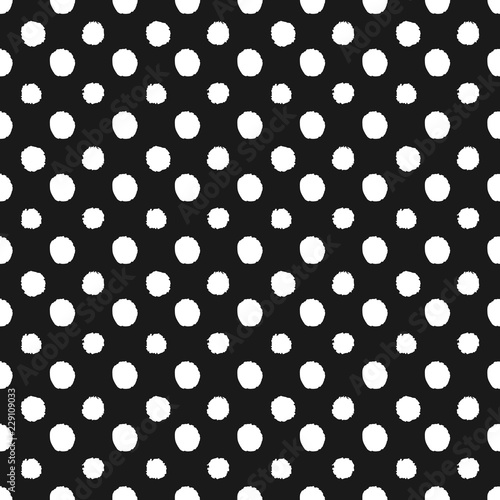 Abstract polka dot seamless pattern in hand drawn style with white dots on black background