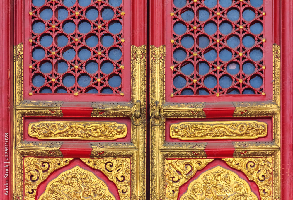 Obraz premium Ornate red wooden door with gold trim and traditional Chinese design in Forbidden City In Beijing China
