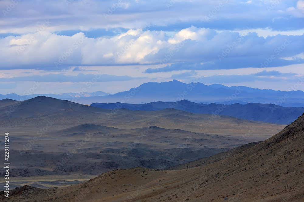Landscape of highland steppe with mountains cloudy dramatic blue sky in during the evening time at Bayan-Ulgii, Mongolia Landscape of highland steppe with mountains cloudy dramatic blue sky in during the evening time at Bayan-Ulgii, Mongolia