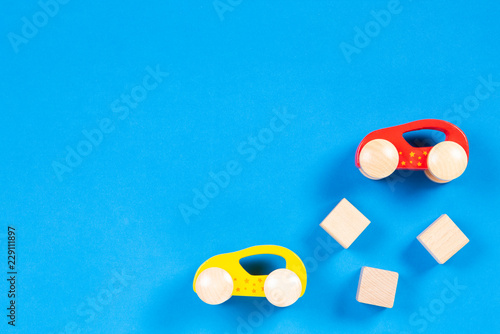Wooden toy cars and blocks on blue color background