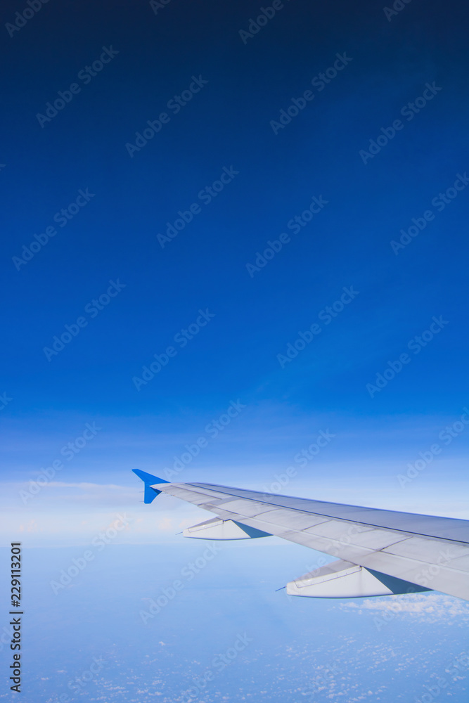 Fototapeta premium top view blue sky with wing of airplane