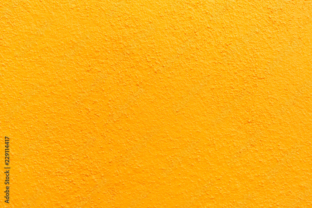 Naklejka premium Stucco wall - Yellow stucco textured wall background with natural light.