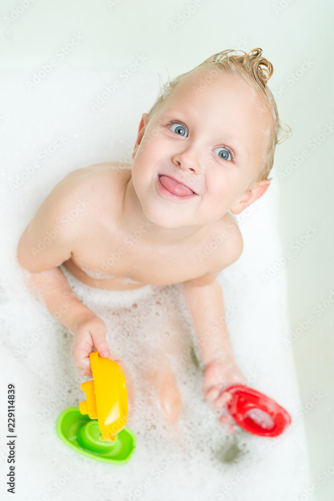 Happy baby bathes in the bathroom with foam Happy baby bathes in the bathroom with foam