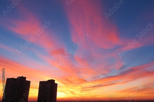 Beautiful fiery red pink sunset background over the city, flame in the sky